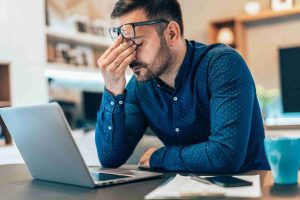 hombre estresado teletrabajando con portátil