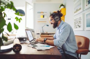joven trabajando desde casa con auriculares