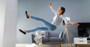 mujer resbalándose de una alfombra en el interior de una casa